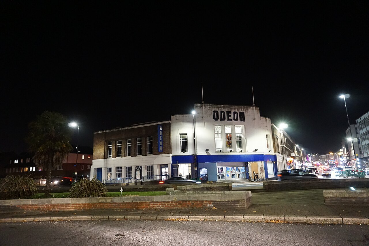 A cinema building lit up at night on a street corner in Beckenham, south-east London